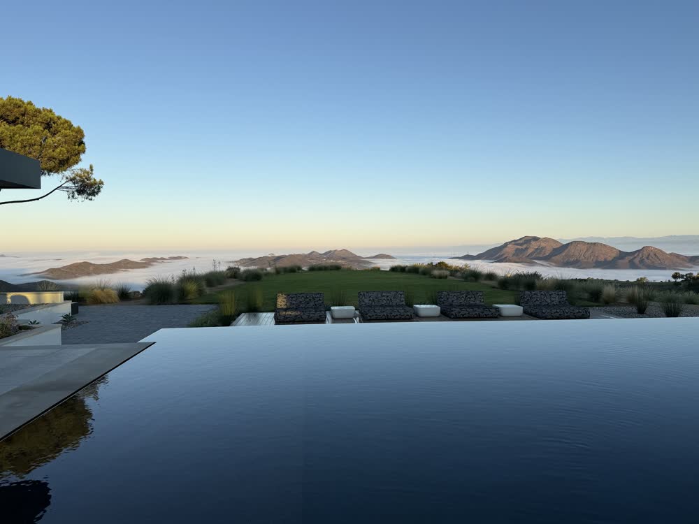 Infinity pool above a valley of clouds at blue hour