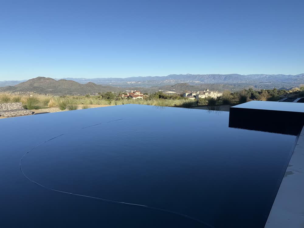 Hillside pool with the lighting on after sunset